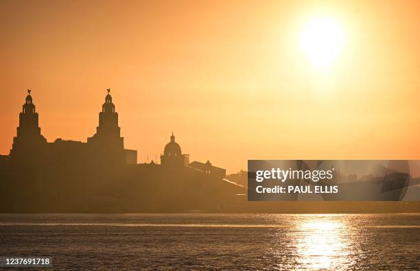 The sun rises across the River Mersey over the skyline of Liverpool in northwest England on January 13, 2022.