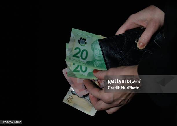 In this photo illustration a nitizen holds Canadian Dollar banknotes. On Wednesday, January 12 in Edmonton, Alberta, Canada.