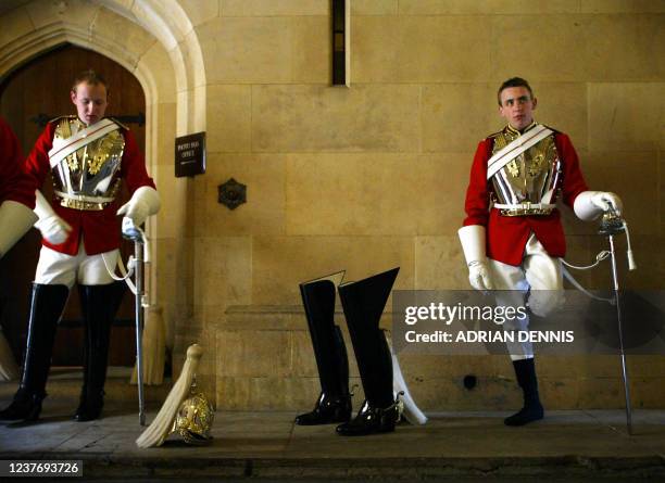 Horse guardsman takes a moment to relax beside his boots before the State Opening of Parliament in London 17 May 2005. Queen Elizabeth addressed the...