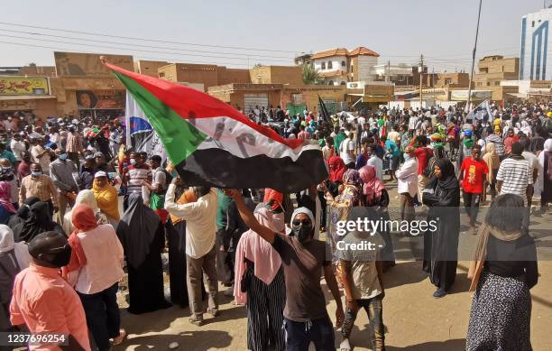 Sudanese demonstrator waves a national flag during a protest against the October 2021 military coup, in the capital Khartoum, on January 13, 2022. -...