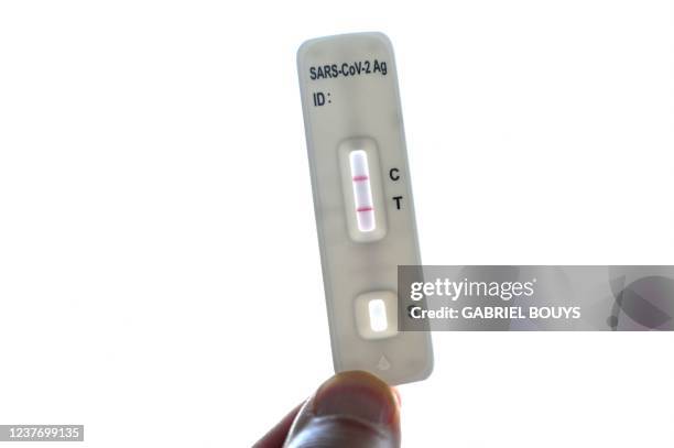 Covid-19 antigen self-test kit shows a positive case on January 13, 2022 in Madrid. - Spain today agreed to cap the cost of Covid antigen tests at...