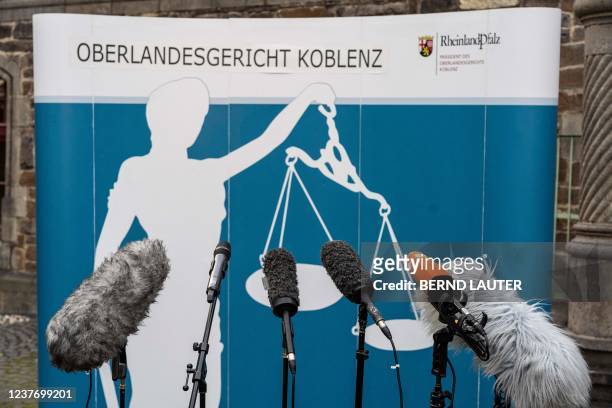 Microphones are set up in front of a banner featuring a "Justitia" ahead of a press conference outside the courthouse in Koblenz, western Germany, on...