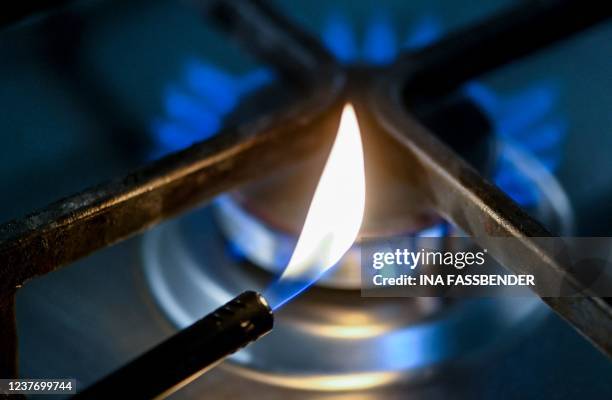 An illustration made on January 13, 2022 in Dortmund, western Germany, shows a flame in front of a burning hob of a gas cooker. - German households...
