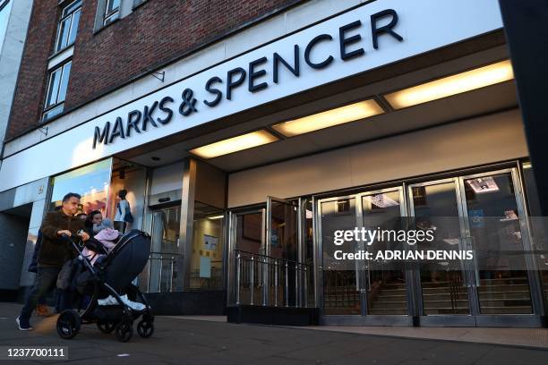 Pedestrians pass a Marks and Spencer store in Guildford, southwest of London on January 13, 2022. - The British chain of stores Marks and Spencer...