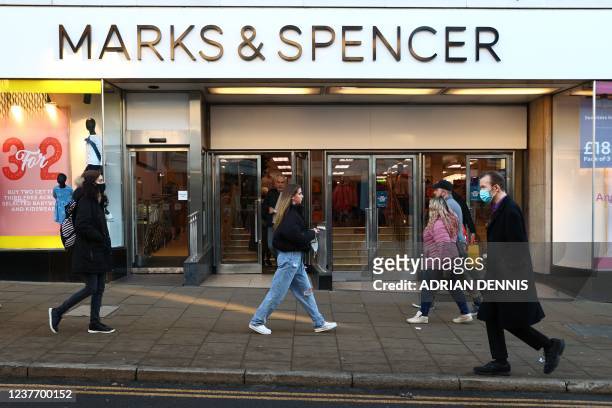 Pedestrians pass a Marks and Spencer store in Guildford, southwest of London on January 13, 2022. - The British chain of stores Marks and Spencer...