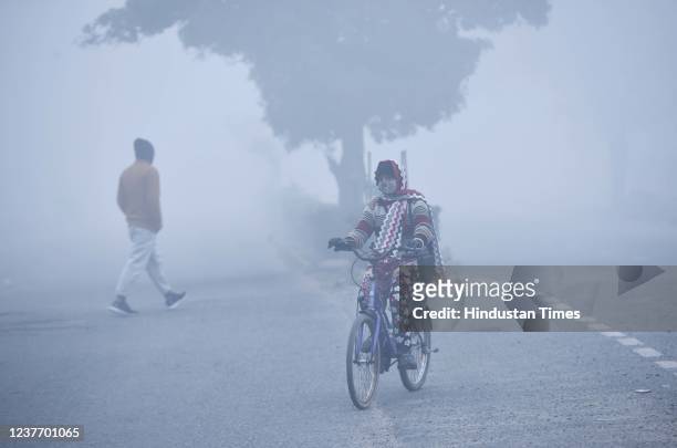 Cyclist out in Dwarka on a foggy winter morning, on January 13, 2022 in New Delhi, India,.