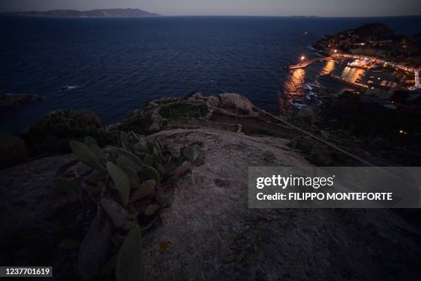 General view shows the port of Giglio on January 13 and the spot where the Costa Concordia cruise ship ran aground and keeled over off Giglio island,...