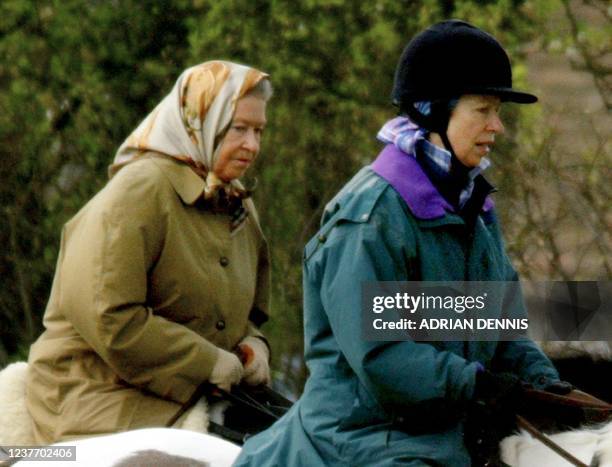 Queen Elizabeth II and her daughter Princess Anne ride in the grounds of Windsor Castle 02 April 2002. The body of Queen Elizabeth, The Queen Mother,...