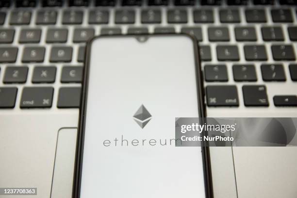 In this photo illustration an Ethereum logo seen displayed on a smartphone screen with a computer keyword in the background in Athens, Greece on...
