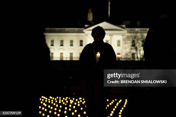 An activist holds a candle during a vigil in Lafayette Park for nurses who died during the COVID-19 pandemic on January 13 in Washington, DC.