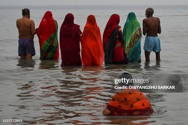 Hindu pilgrims perform a prayer ritual after taking a holy dip at the confluence of Ganges and the Bay of Bengal during the Gangasagar Mela on the...