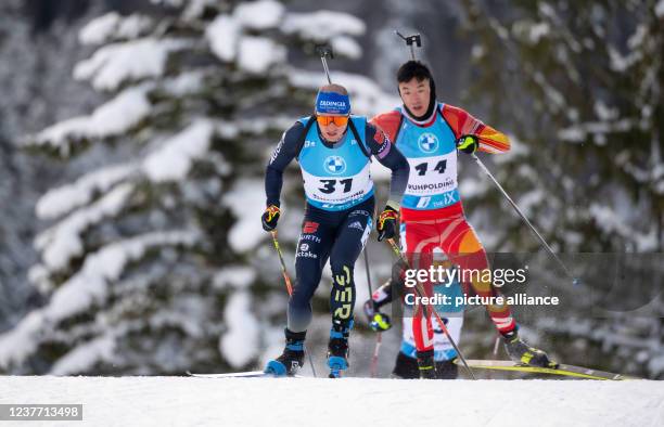 January 2022, Bavaria, Ruhpolding: Biathlon: World Cup, Sprint 10 km in Chiemgau Arena, men. Erik Lesser from Germany and Fangming Cheng from China...