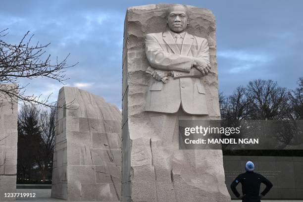 Jogger looks at The Stone of Hope, a granite statue of civil rights leader Martin Luther King Jr., at his memorial in Washington, DC, on January 14,...