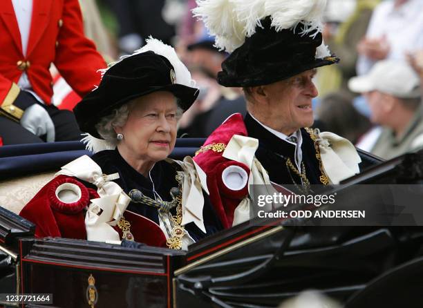 Queen Elizabeth II and the Duke of Edinburgh ride in an open horse drawn carriage after the Garter service at the St George's chapel at Windsor...