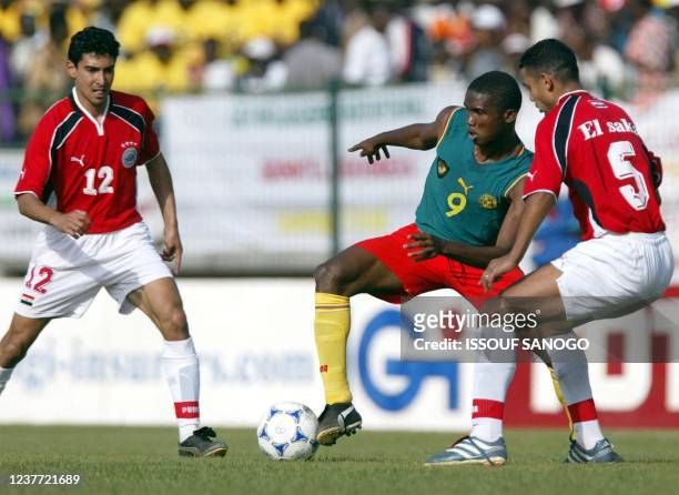 Cameroon's forward Samuel Eto'o Fils fights with the ball with Egyptian Mohamed Barakat and El Saka El Zaher 04 February 2002, during their African...