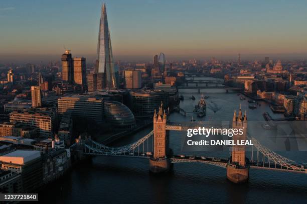 An overhead view shows Tower Bridge, spanning The River Thames, The Shard and buildings in central London as the sun rises in London on January 14,...