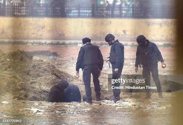 Members of the NSG bomb disposal squad seen working to diffuse an improvised explosive device at the Ghazipur flower market in East Delhi after the...