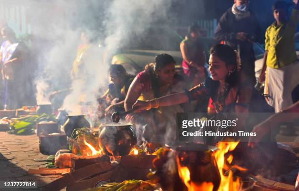 Tamil women celebrate harvest festival of Pongal in ancient way by cooking special food wearing traditional attire at Dharavi on January 14, 2022 in...