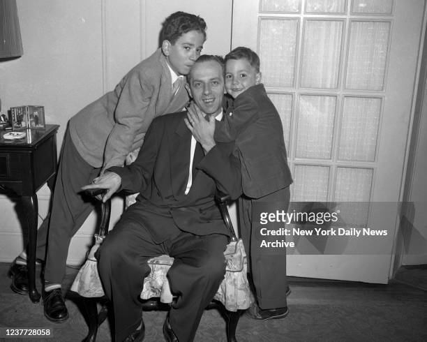 Christopher Emmanuel "Manny" Balestrero is hugged by sons Robert and Gregory at Woodside, Queens, home after receiving word that another man...