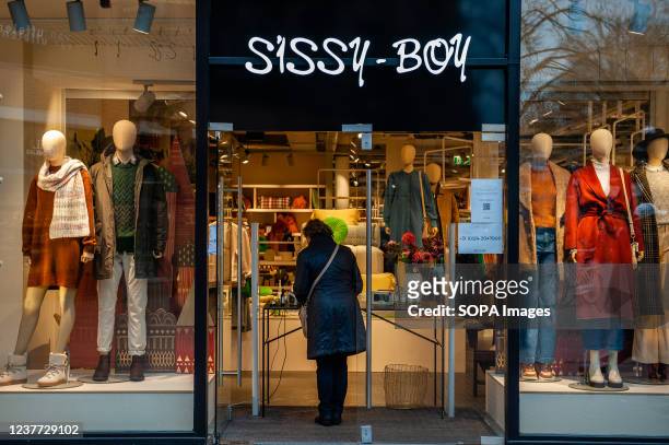 Woman is seen waiting outside Sissy-Boy fashion store to pick up her order from the store. Tonight, the cabinet is expected to announce a relaxation...