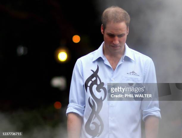 Britain's Prince William stands over a traditional Maori earth oven called a 'hangi' at Government House on the first day of his visit to Auckland on...