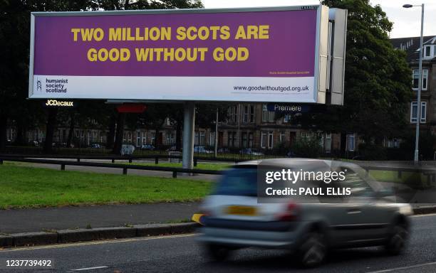 Car drives past an advertising board ahead of the visit of Pope Benedict XVI in Glasgow, Scotland on September 16, 2010. The first state visit of a...