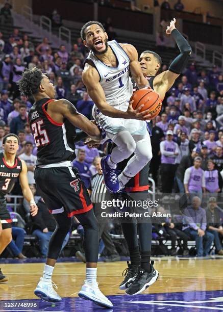 Markquis Nowell of the Kansas State Wildcats drives to the basket between Kevin McCullar and Adonis Arms of the Texas Tech Red Raiders, during the...