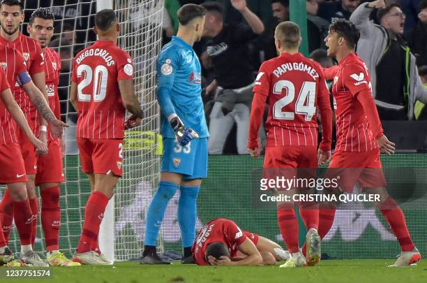 Sevilla's Spanish midfielder Joan Jordan Moreno lies on the pitch after being hit by an object thrown from the tribunes during the Spanish Copa del...