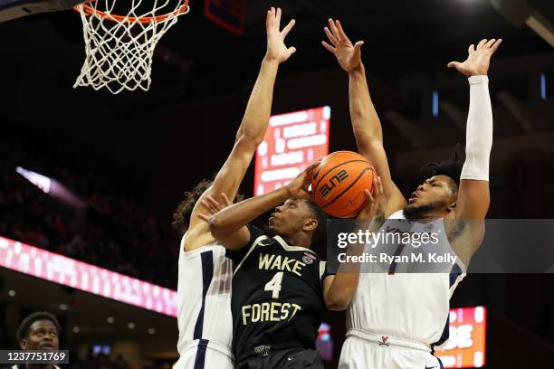 Kadin Shedrick and Jayden Gardner of the Virginia Cavaliers defend a shot by Daivien Williamson of the Wake Forest Demon Deacons in the first half...