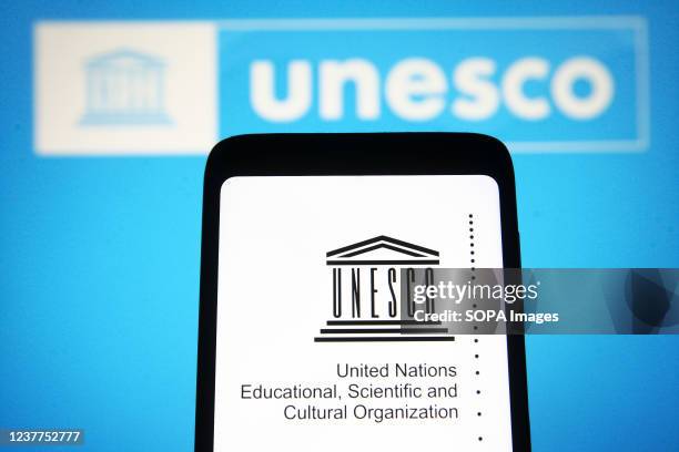 In this photo illustration, UNESCO logo is seen on a smartphone screen and in the background.