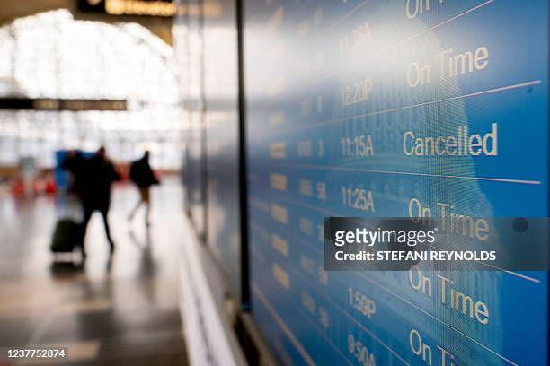 "Cancelled" is displayed on a flight schedule board at Ronald Reagan Washington National Airport in Arlington, Virginia, on January 15, 2022.
