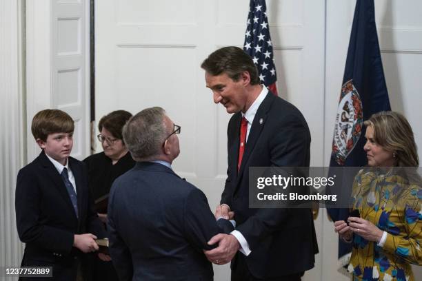 Glenn Youngkin, governor of Virginia, center, greets Andrew Wheeler, Virginia's incoming secretary of natural resources, during a cabinet swearing-in...