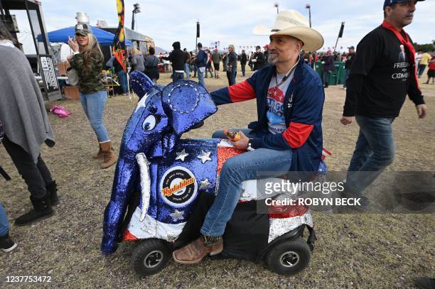 Supporter rides a scooter decked out like an elephant, symbol of the Republican party, as he attends former U.S. President Donald Trump's first rally...