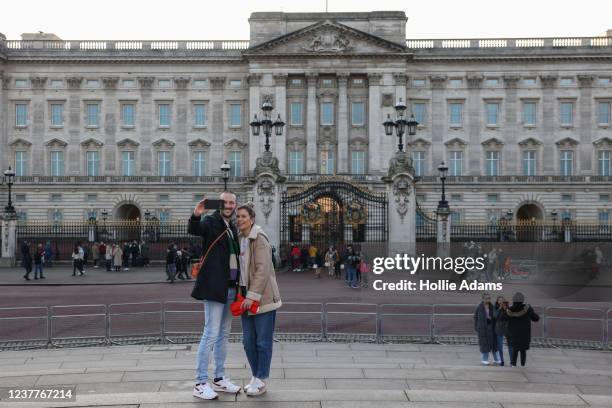 People pose for photos outside Buckingham Place on January 16, 2022 in London, England. On Thursday, Buckingham Palace announced Prince Andrew would...