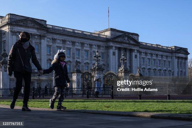 Pedestrians walk past Buckingham Place on January 16, 2022 in London, England. On Thursday, Buckingham Palace announced Prince Andrew would shed his...