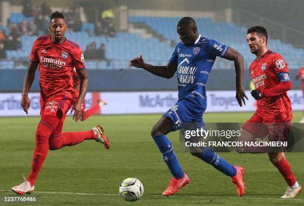 Troyes' Portuguese defender Abdu Conte fights for the ball with Lyon's German defender Jerome Boateng and Lyon's French defender Leo Dubois during...