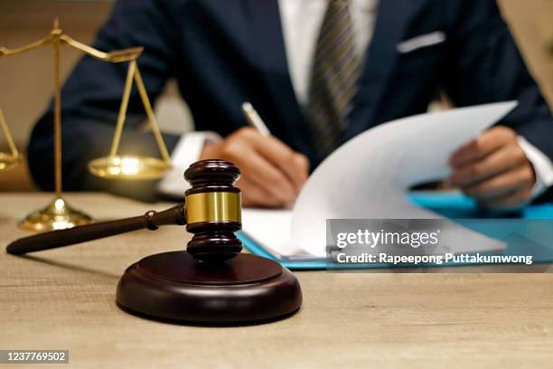 lawyer working in the office. gavel and blurred lawyer working - legal assistance stock pictures, royalty-free photos & images