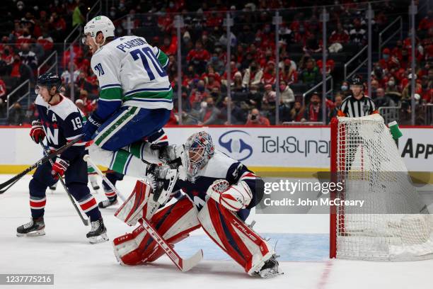 Washington Capitals goaltender Ilya Samsonov fights to see through a jumping Vancouver Canucks left wing Tanner Pearson during a game at Capital One...