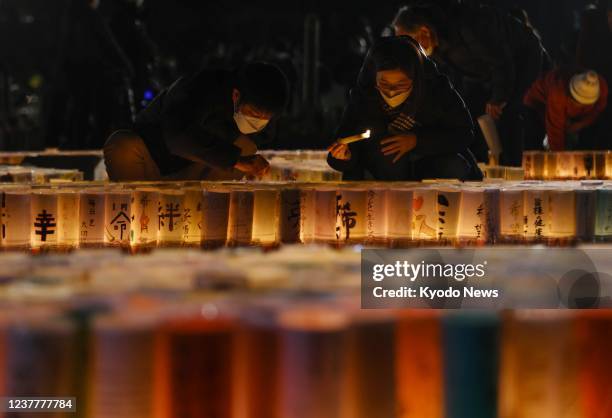 People light lanterns during a memorial event at a park in Kobe, Hyogo Prefecture, early on the morning of Jan. 17 the 27th anniversary of the Great...