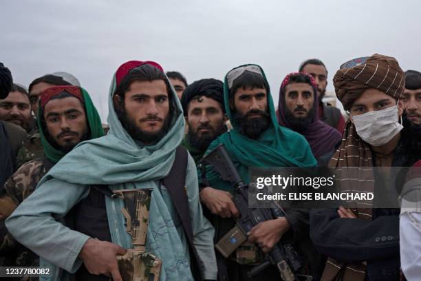 In this photograph taken on January 16 Taliban fighters watch while standing on guard during a military street parade in Maymana, capital of Faryab...