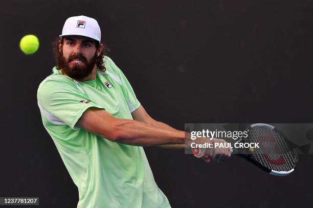 Reilly Opelka of the US hits a return against South Africa's Kevin Anderson during their men's singles match on day one of the Australian Open tennis...