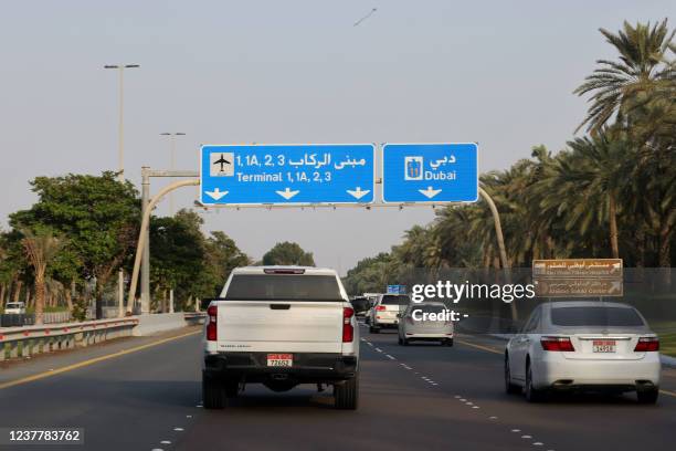 Drivers take a road leading to Abu Dhabi's airport in the capital of the United Arab Emirates, Abu Dhabi, on January 17, 2022. - Three people were...