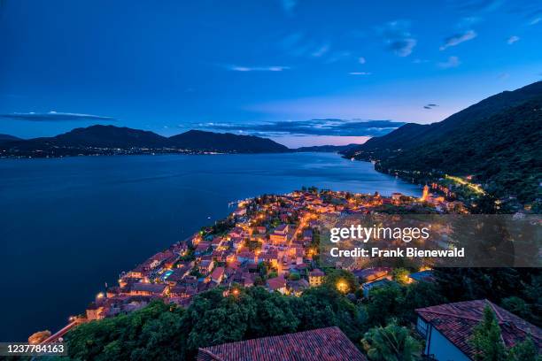 View of the church Chiesa Parrocchiale di San Giorgio, Lake Maggiore and the surrounding mountains at night.