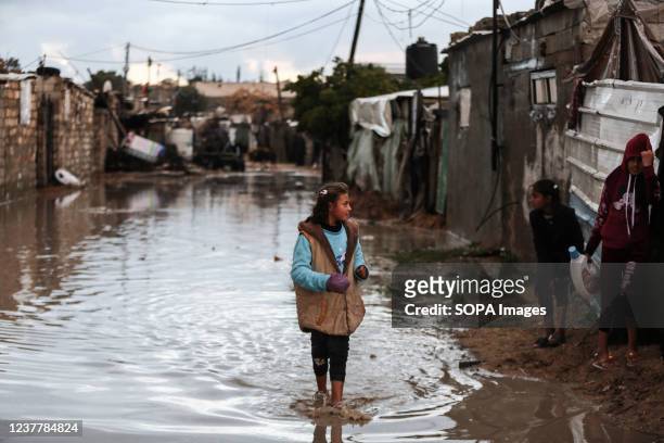 Palestinian girl walks on a flooded road on a rainy day in the outskirts of Khan Yunis refugee camp in the southern Gaza Strip.
