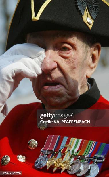 Chelsea Pensioner wipes his eye as the coffin of the Queen Mother passes by during a ceremonial procession to Westminster Hall in central London,...