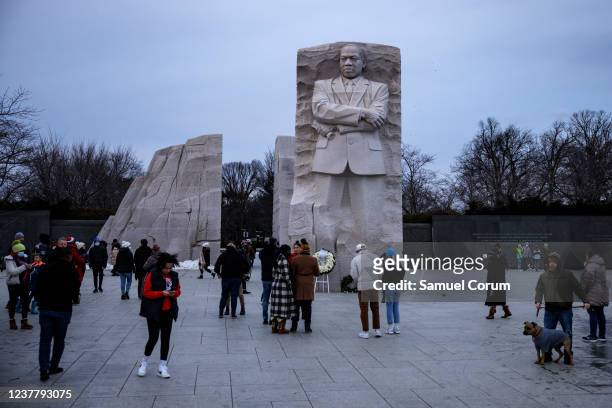 People walk around the statue of civil rights leader Dr. Martin Luther King Jr. At his memorial site on the edge of the Tidal Basin, which was...