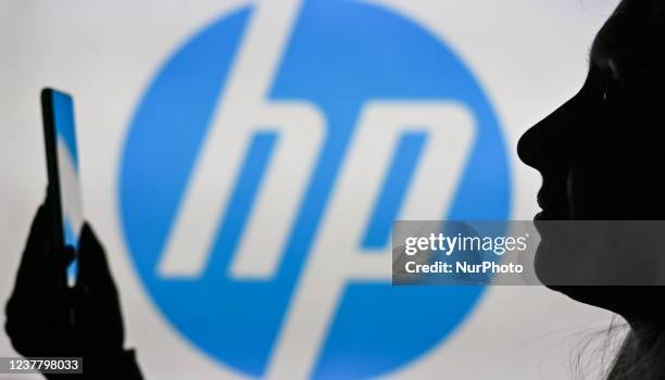 An image of a woman holding a cell phone in front of the Hewlett-Packard logo displayed on a computer screen. On Tuesday, January 12 in Edmonton,...