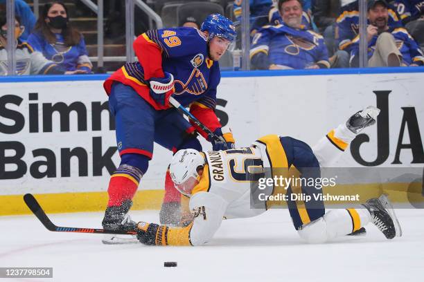 Mikael Granlund of the Nashville Predators falls to the ice fighting Ivan Barbashev of the St. Louis Blues for the puck during the third period at...