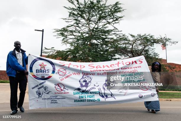 Members of the Broad Alliance Against Sanctions protest at the US Embassy in Harare on December 20, 2021 with banners calling for the lifting of...
