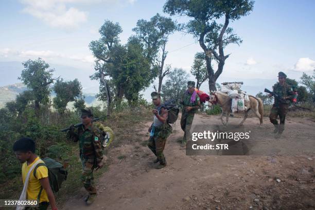 This photo taken on January 4, 2022 shows soldiers from the Taaung National Liberation Army , a Palaung ethnic armed group, walking near their...